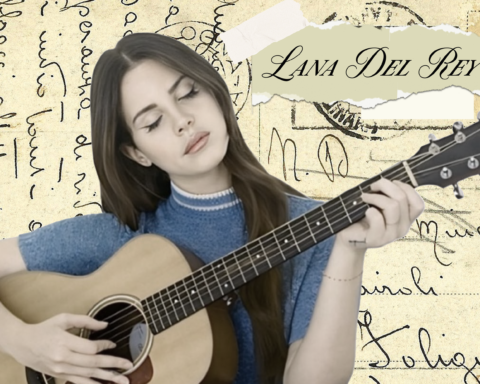 A woman with brown hair and a blue sweater is sitting in front of a background of paper covered in writing, intimately strumming a guitar. Her eyes are closed and her lips set in a stoic position, implying she is in deep contemplative as she parcels out each individual note. Her name -- Lana Del Rey -- is written on a torn piece of paper, taped to the background in the upper-right corner.
