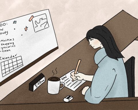Person taking notes in front of their organized calendar.
