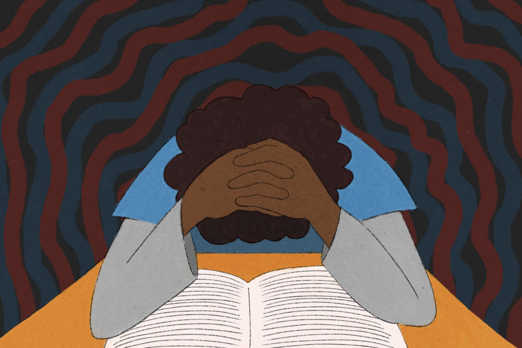 POC with head in hands over a book.